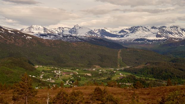 A picturesque village nestled in a valley surrounded by majestic snow-capped mountains.
