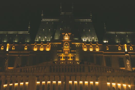Night view of the beautifully illuminated Palace of Culture in Iași, Romania, showcasing Neo-Gothic architecture.