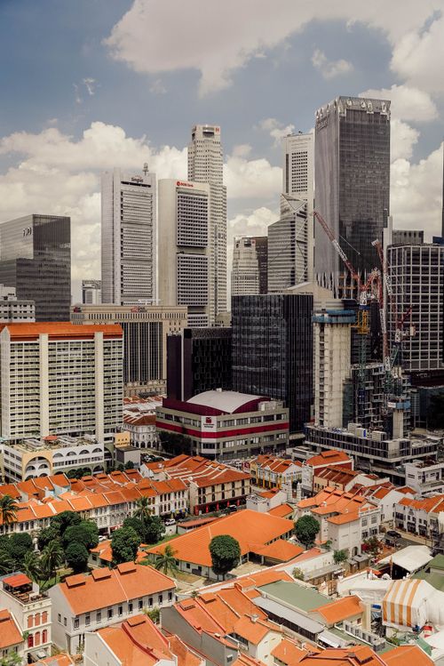 Free Aerial view of Singapore's cityscape featuring modern skyscrapers and traditional red-roofed buildings. Stock Photo