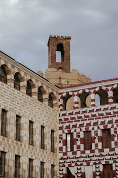 Historic buildings with intricate patterns and a tower in Badajoz, Spain.