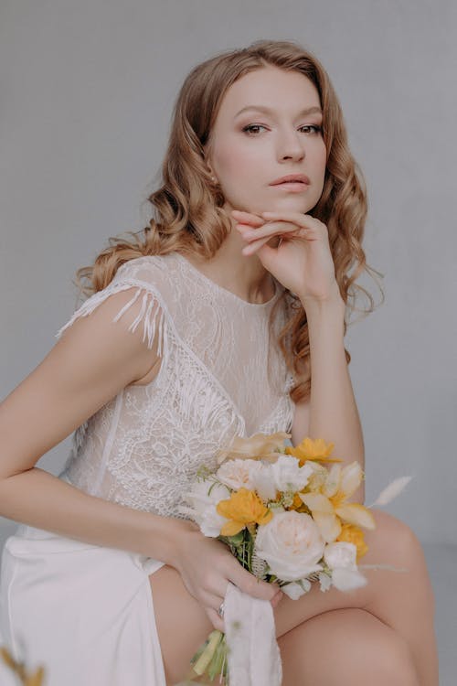 Close-Up Shot of a Woman in White Dress Holding a Bridal Bouquet