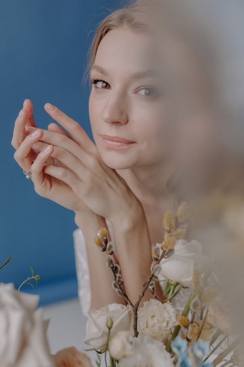 Free Close-up portrait of a woman surrounded by delicate flowers, exuding elegance and calmness. Stock Photo