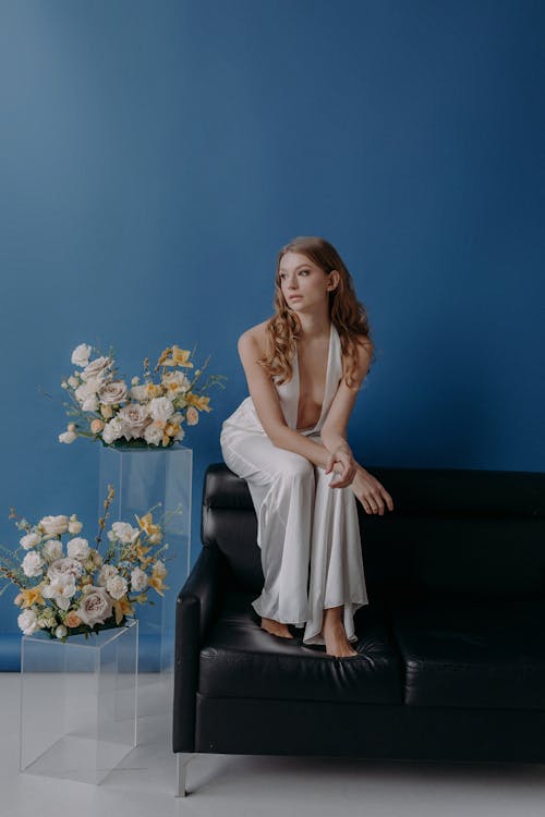 A Woman in White Dress Sitting on the Couch