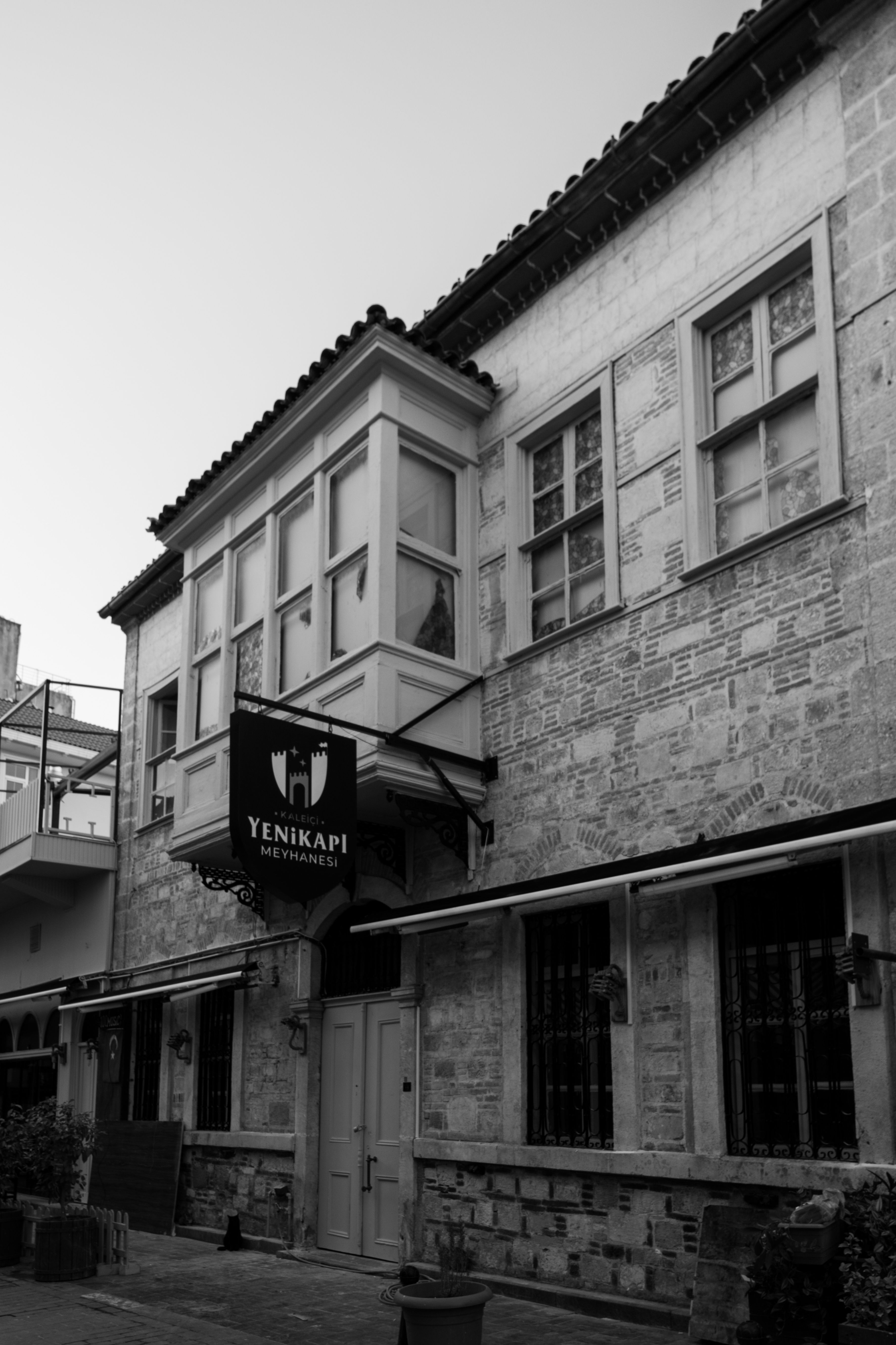 Black and white photo of a historic building facade with rustic architecture.
