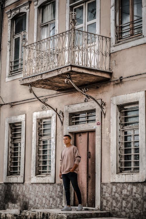 Man Standing in front of an Old Tenement House in City 