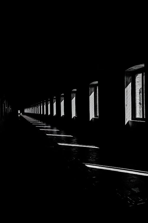 A Grayscale Photo of a Dark Corridor inside a Building