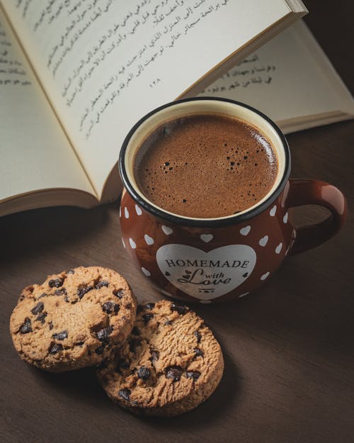 Free Chocolate Chip Cookies and a Mug of Coffee Next to a Book Stock Photo