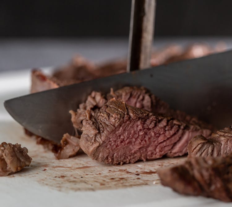 A Person Cutting A Steak 