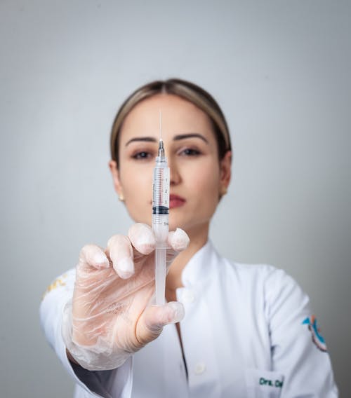 Close-Up Shot of a Woman Holding a Syringe