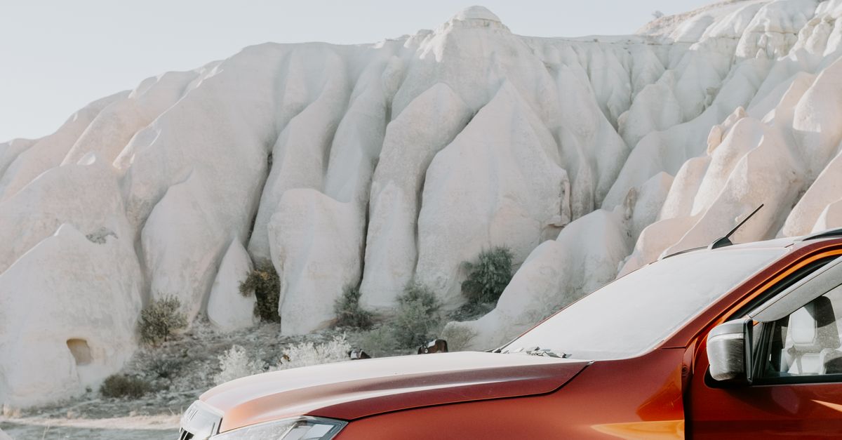 Closeup of a Red Terrain Car in White Rocks Landscape · Free Stock Photo