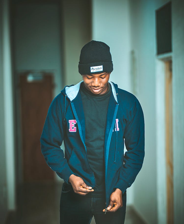 Photo Of A Man In Black Beanie Zipping Up His Jacket