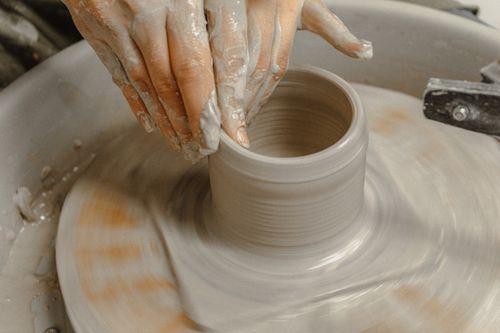 Free Close-up of hands shaping a clay pot on a pottery wheel, showcasing artisanal craftsmanship. Stock Photo