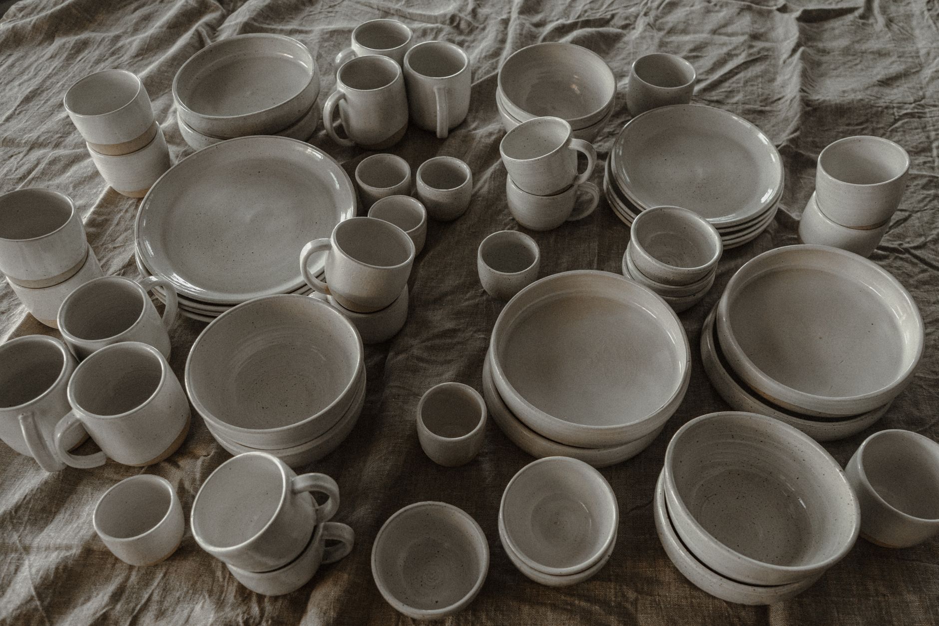 Beautiful collection of ceramic tableware arranged on a textured cloth, perfect for home decor inspiration.