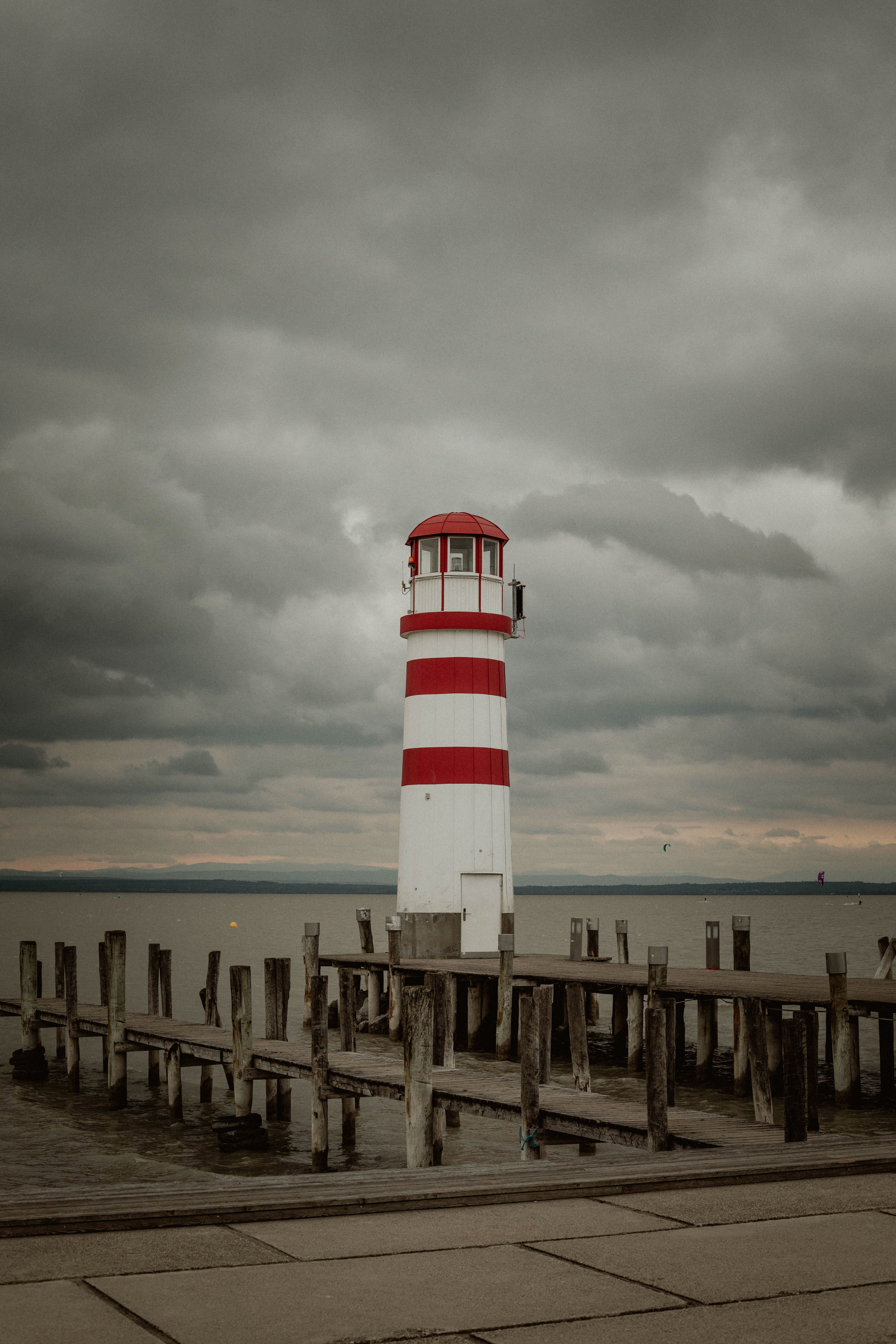 White and Red Lighthouse Under Cloudy Sky · Free Stock Photo