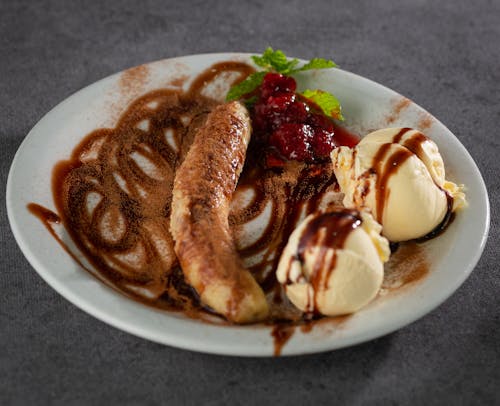Ice Cream with Banana Decorated with Cocoa on White Plate