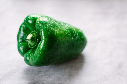 Free Close-up of a fresh green bell pepper with water droplets, highlighting its vibrant color and freshness Stock Photo