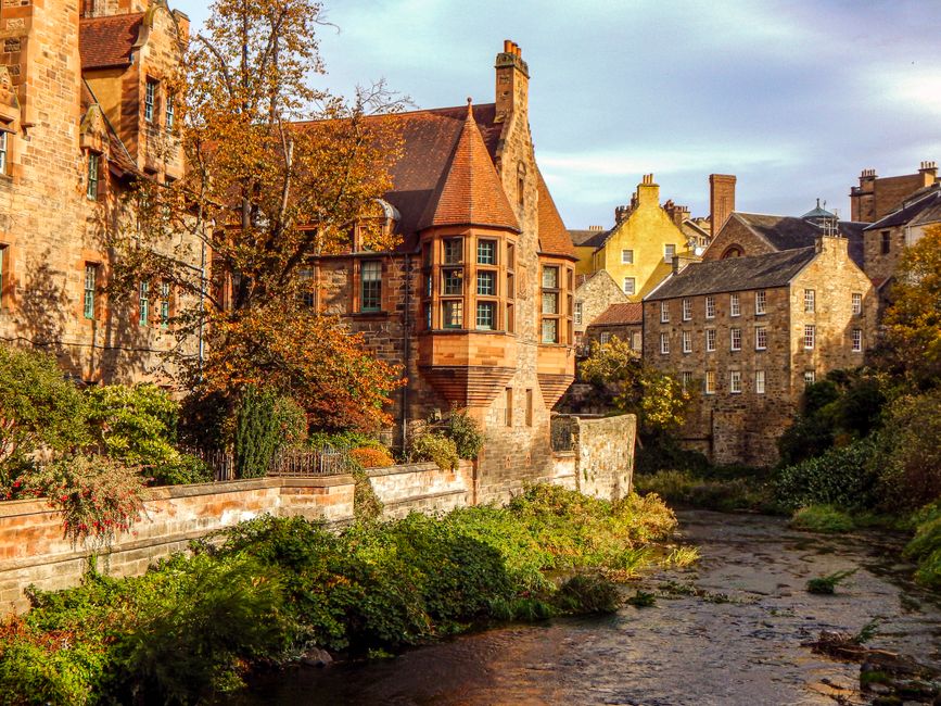 Picturesque autumn scene of historical Dean Village in Edinburgh, Scotland, with vibrant fall foliage.