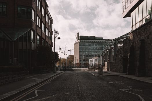 A quiet urban street in Dublin, Ireland, showcasing modern architecture under an overcast sky.