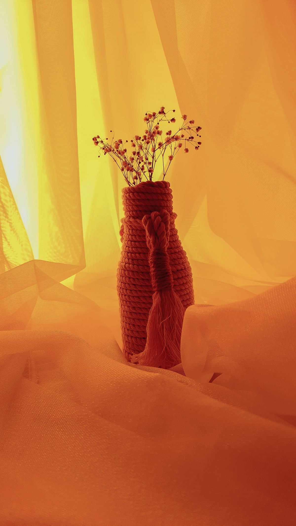 Yarn craft ideas with a yarn-wrapped vase holding dried flowers