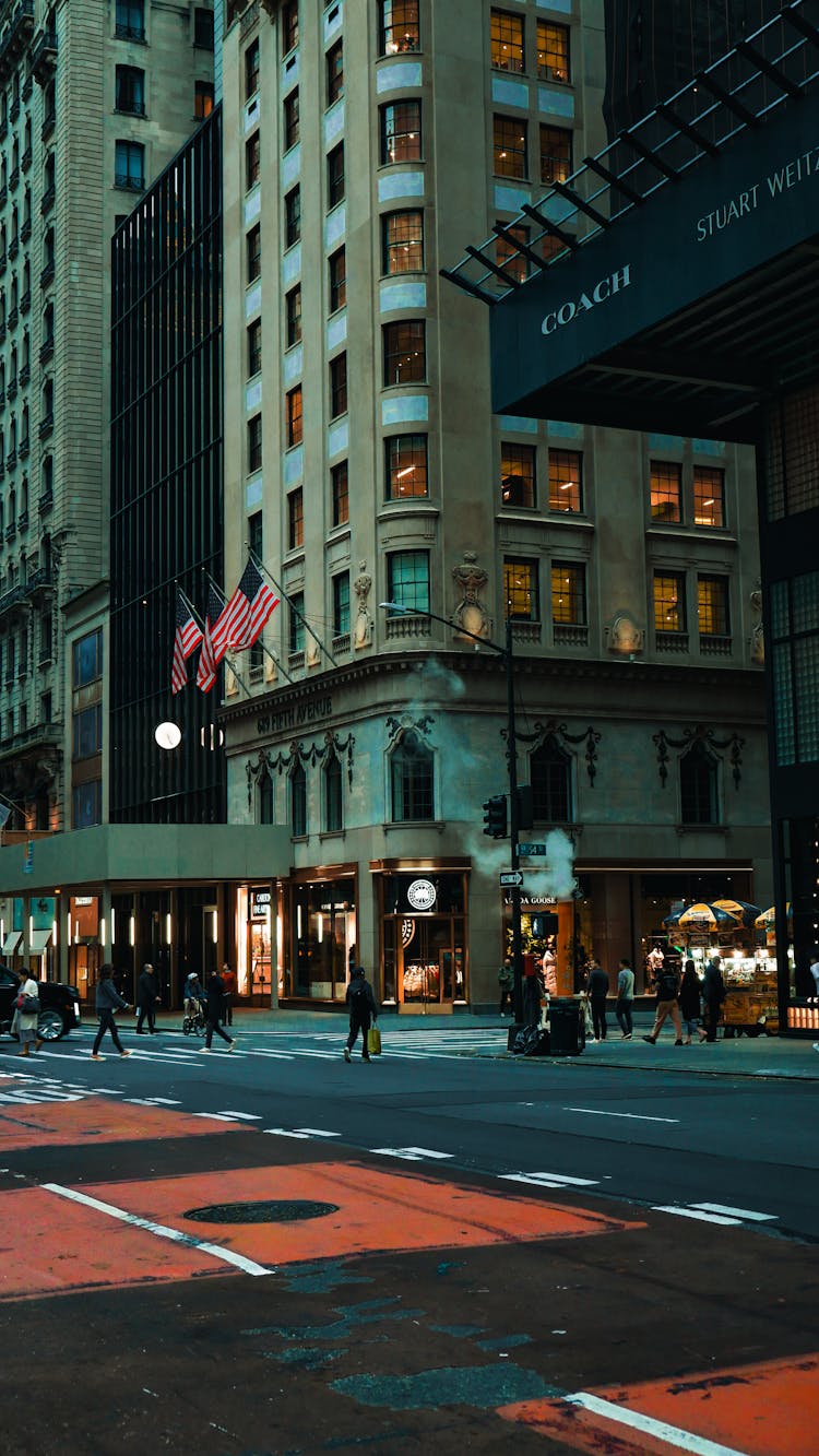 Busy People Crossing The Road Near City Buildings