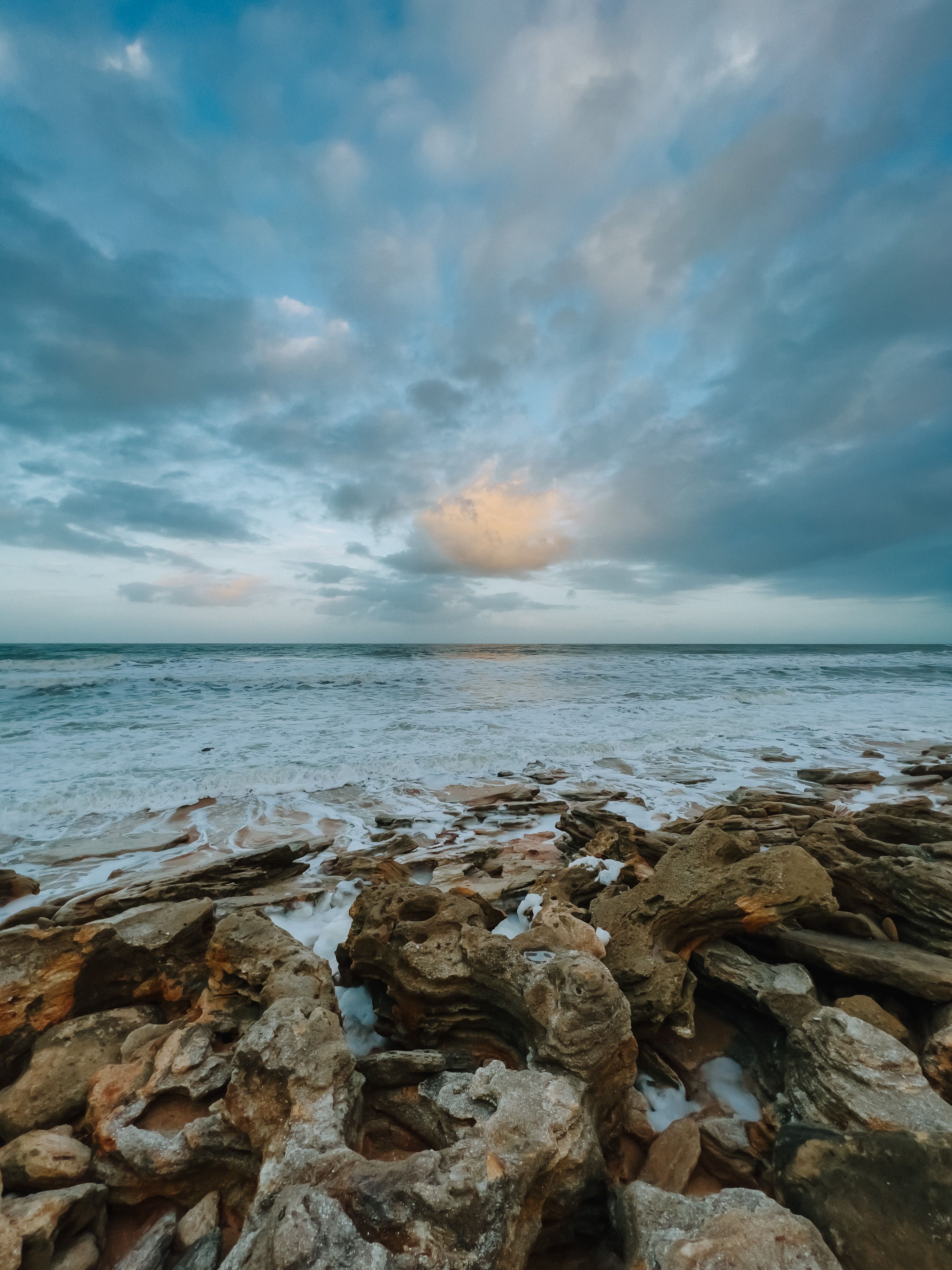 Photo of a Rocky Shore Under a Cloudy Sky · Free Stock Photo