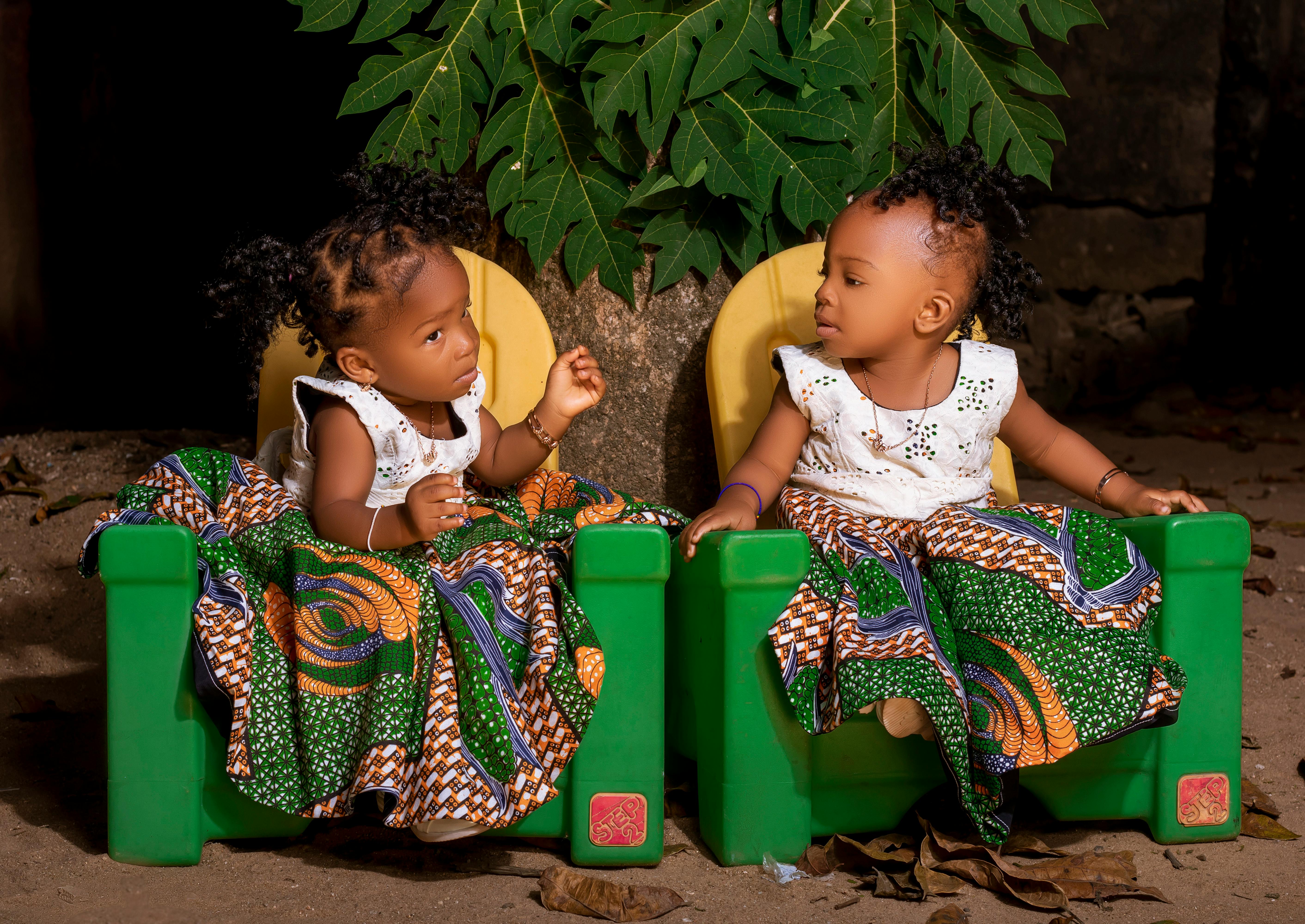 Twins Sitting on Plastic Chairs · Free Stock Photo