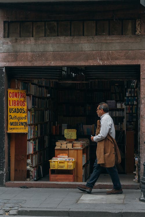 A Man Walking Beside a Bookstore