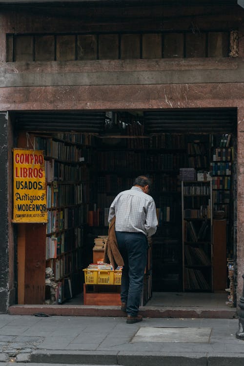 Photo of a Man Walking to a Bookstore