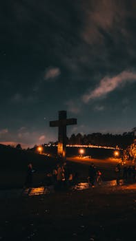 A serene night scene at a cemetery in Stockholm with a cross and mourners under a starlit sky.