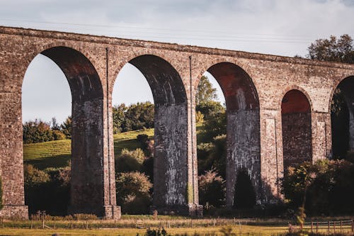 Ancient Aqueduct near Hill with Trees