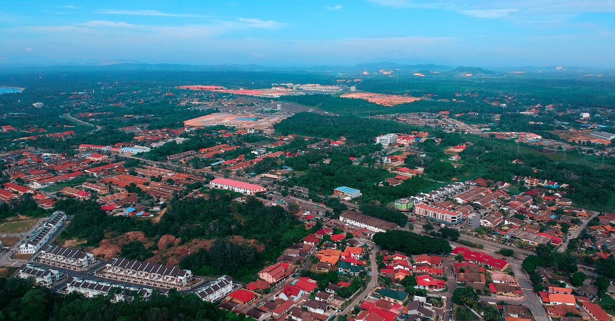An aerial view of a suburban area showcasing vibrant red roofs and greenery.