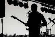 户外音乐会上，吉他手表演的剪影捕捉了音乐的精髓