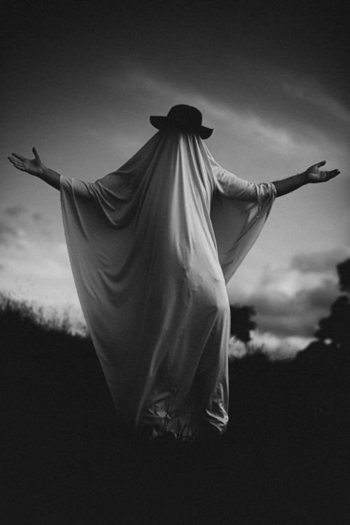 Free Black and white eerie figure depicted as a ghost in an open landscape. Stock Photo