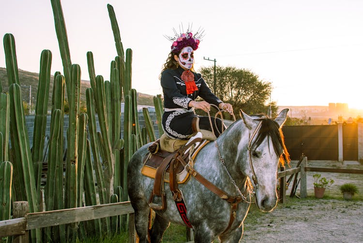 A Woman Wearing A Halloween Costume Riding A Horse