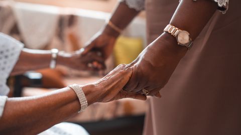 A close-up of two people holding hands, symbolizing support and togetherness.