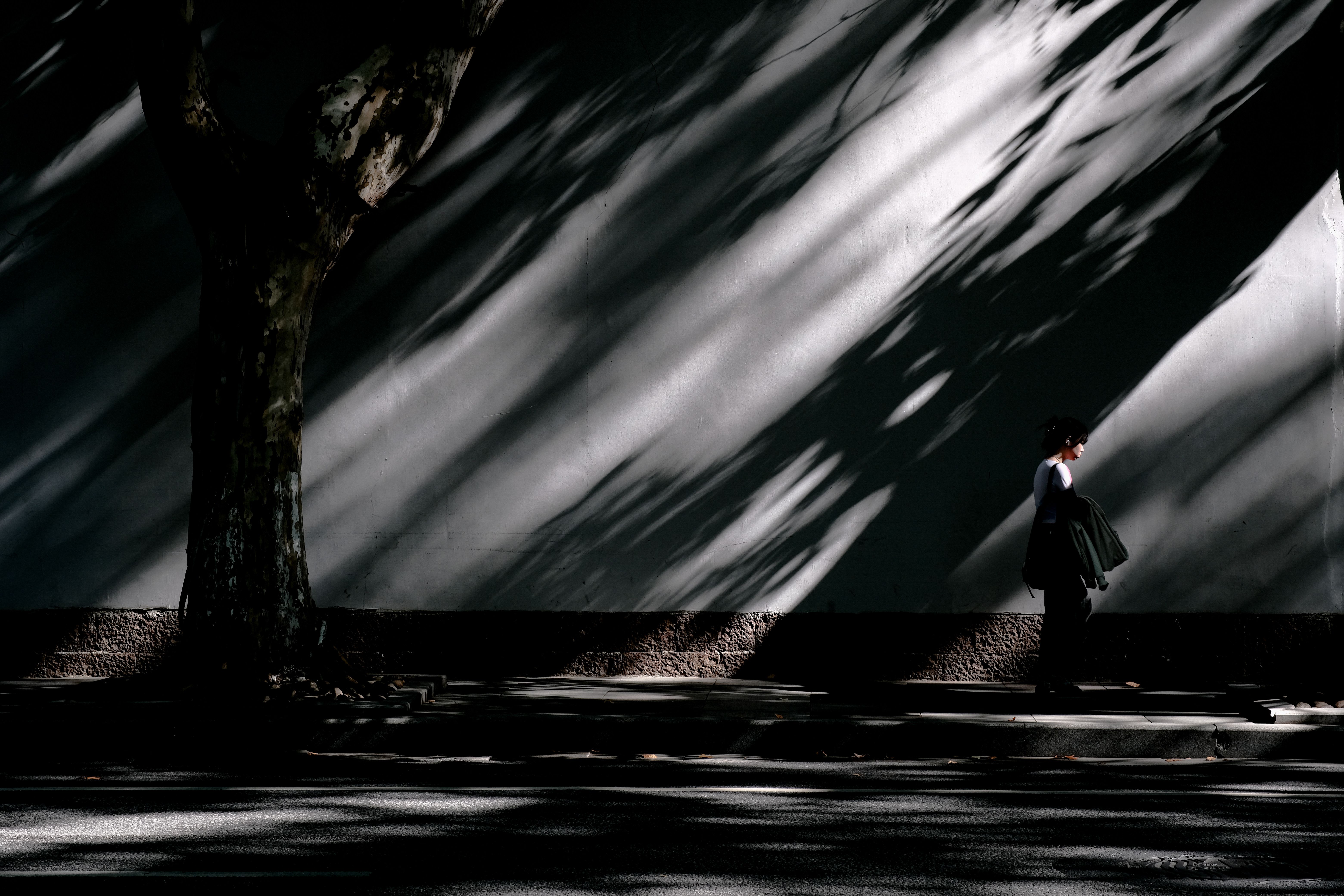 A Person Walking Near Shadows on a Wall · Free Stock Photo