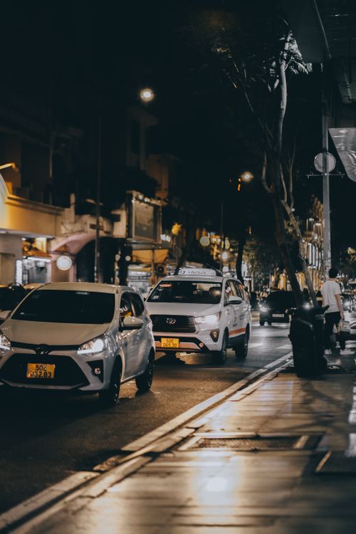 Free A bustling city street at night with cars and glowing streetlights. Stock Photo