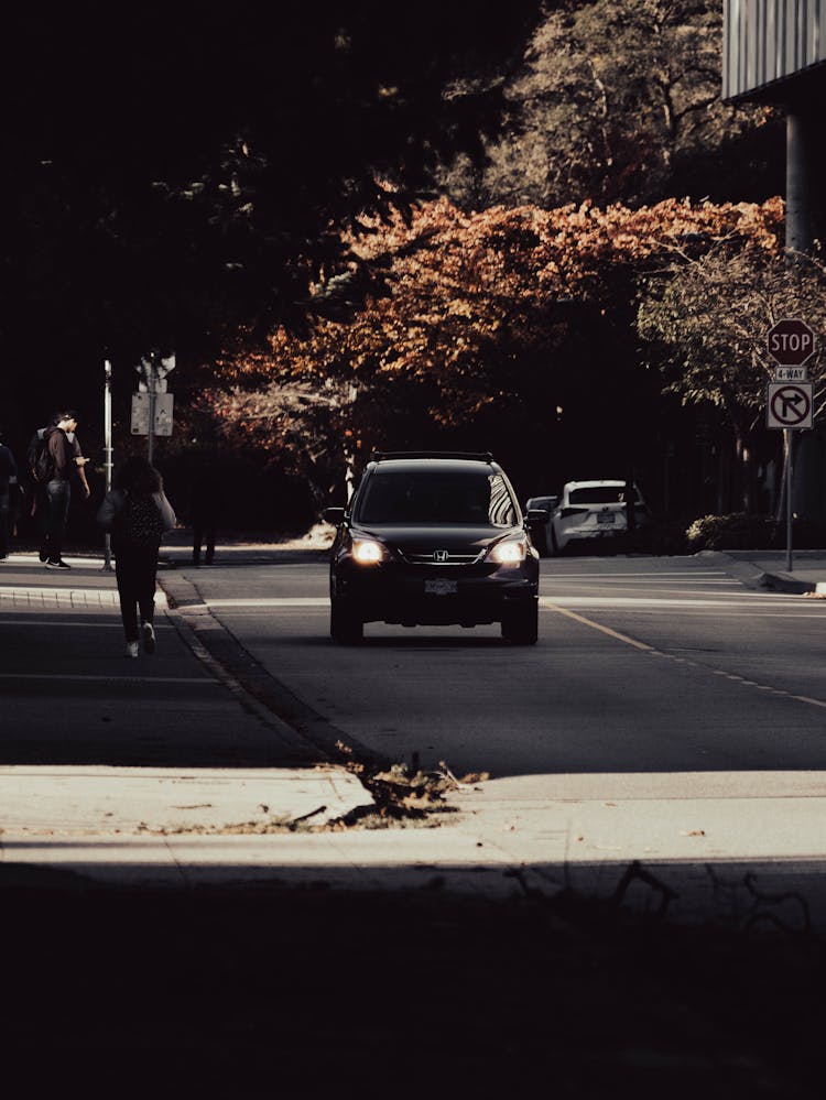 A Black Car Driving On The Road