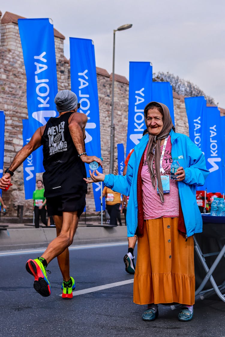 Elderly Woman Giving Water Bottles