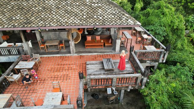 Aerial photo of a tropical terrace with people relaxing in a vibrant and lush environment.