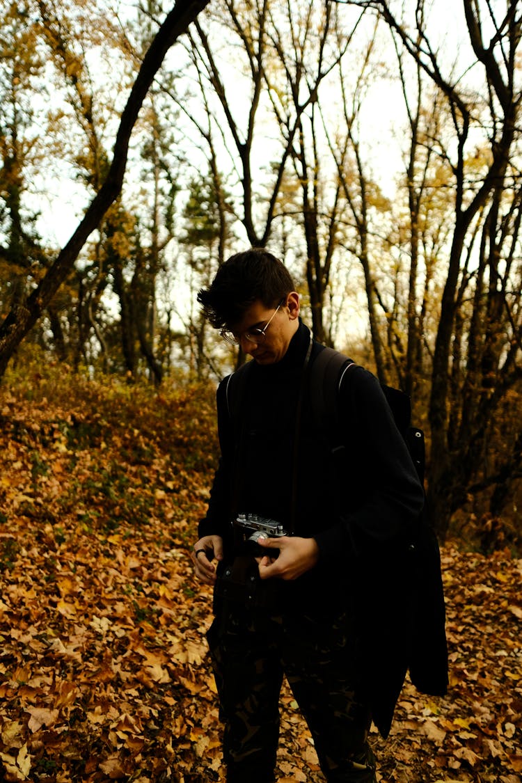 A Man In Black Clothes Holding A Camera