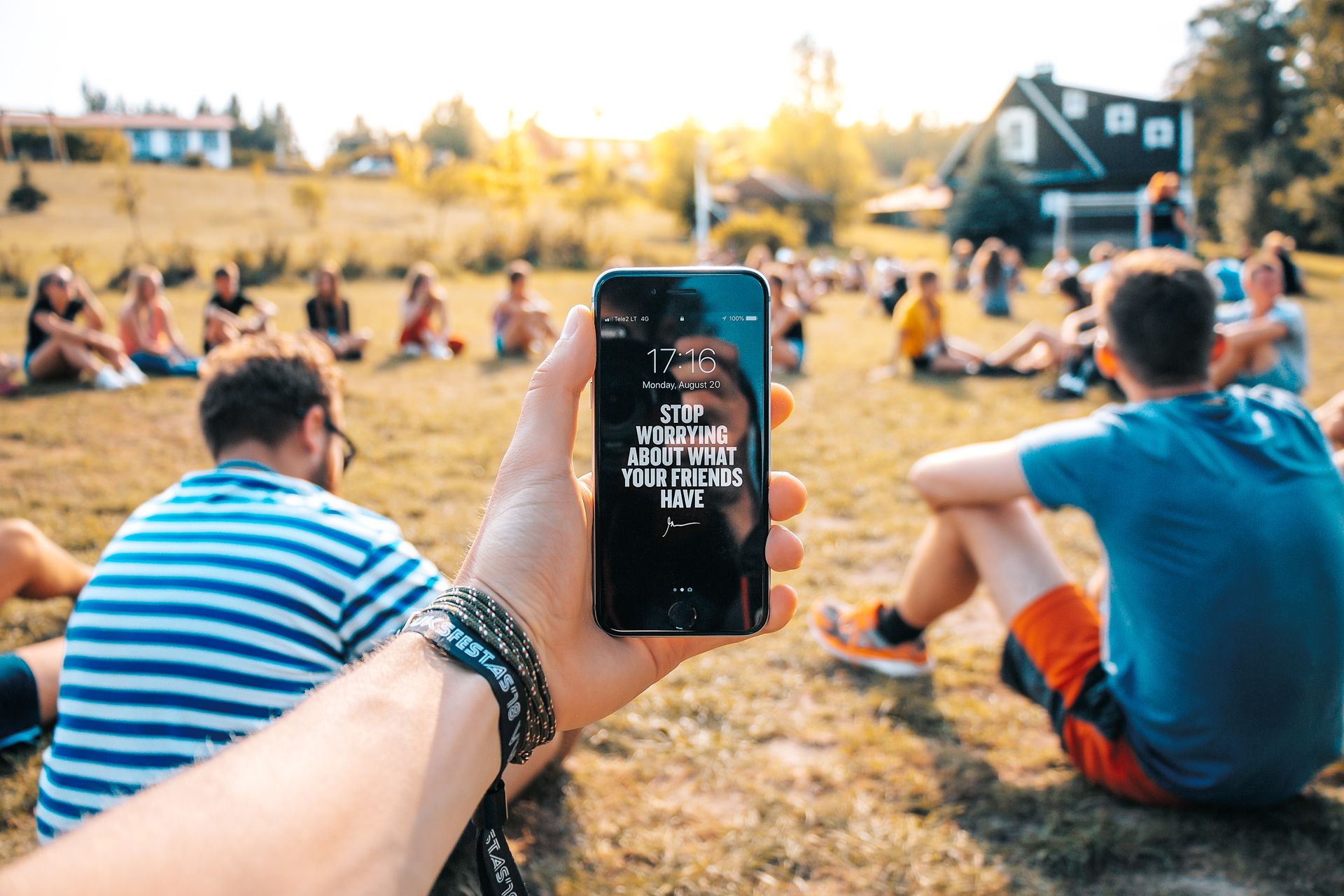 A smartphone with an inspirational message at a friendly outdoor gathering in Vilnius, Lithuania.