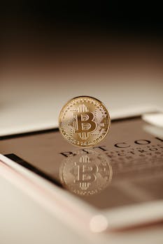 Close-up view of a Bitcoin coin reflecting on a tablet, symbolizing cryptocurrency technology.