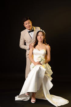 Studio portrait of a newlywed couple in elegant attire, capturing a timeless wedding moment.