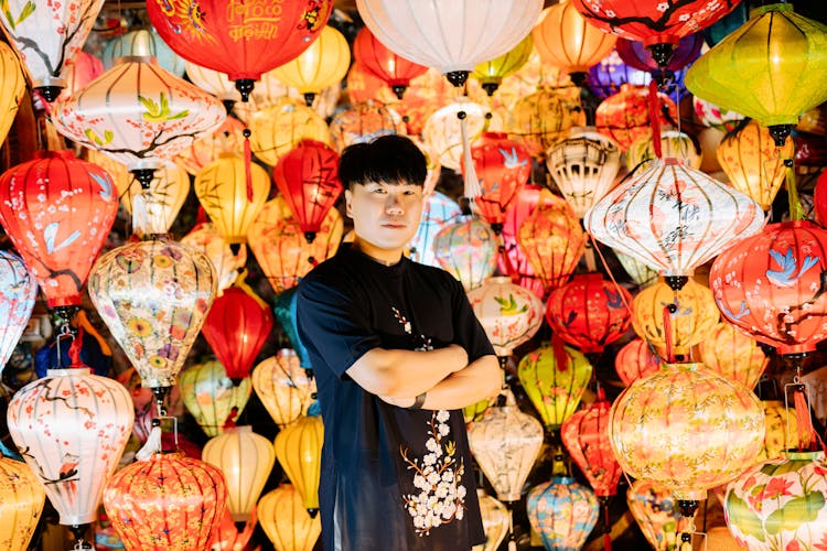 A Man Crossing His Arms Near Lanterns