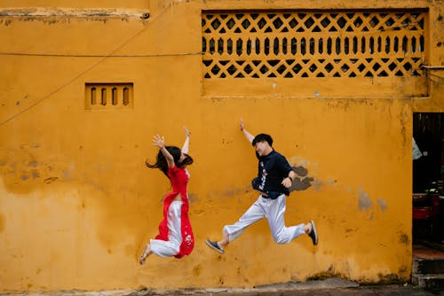 Happy Young Man and Woman Jumping 