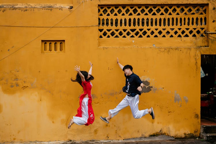 Happy Young Man And Woman Jumping 