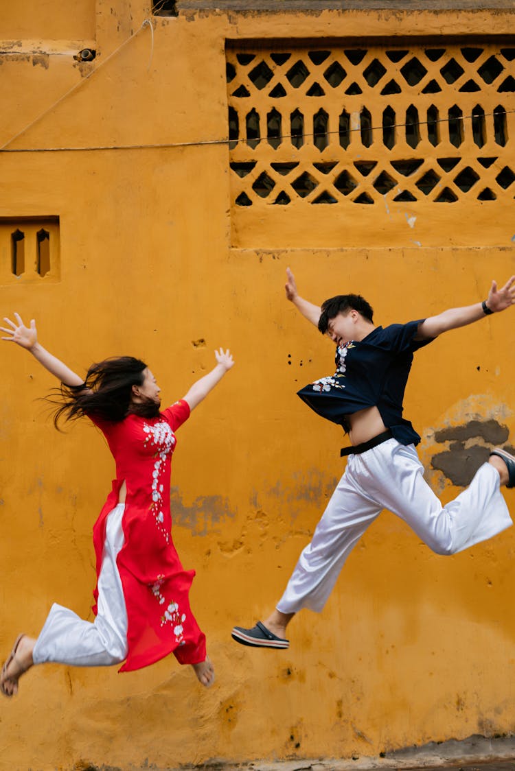 Happy Young Man And Woman Jumping 