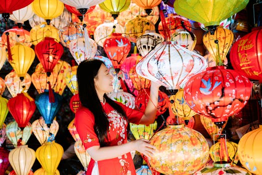 A young woman in traditional dress admires vibrant hanging lanterns, capturing the festive spirit and culture.
