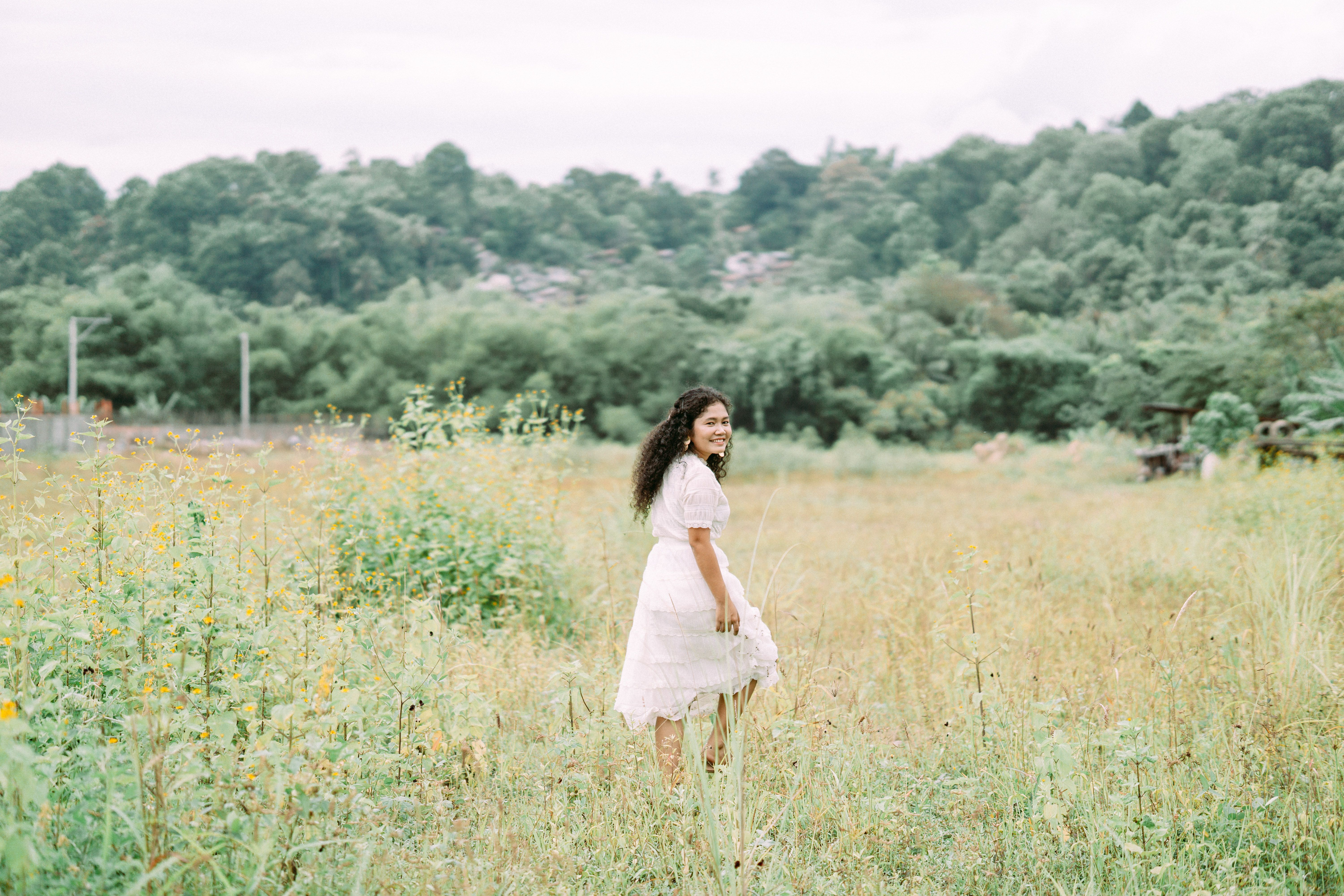 Woman in White Dress Walking on a Green Grass Field · Free Stock Photo